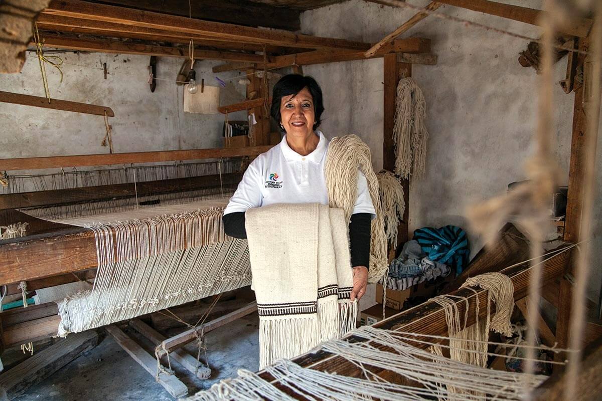 Artesana mexicana trabajando textiles en su taller, ejemplo de la economía productiva local